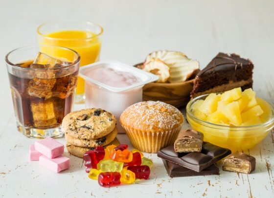 Foto colorida de balinhas, cupcakes, suco, refrigerante, bolo e guloseimas - Metrópoles