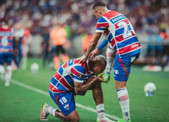Imagem coloria de Deyverson beijando a chuteira de Breno Lopes, em jogo do Fortaleza - metrópoles