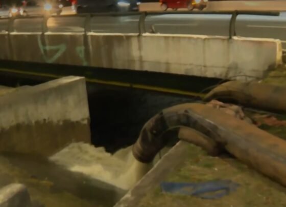 Imagem colorida de esgoto sendo despejado no rio Tietê