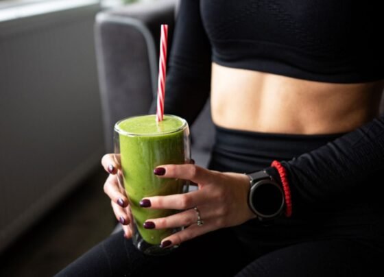 Imagem colorida de mulher bebendo suco verde