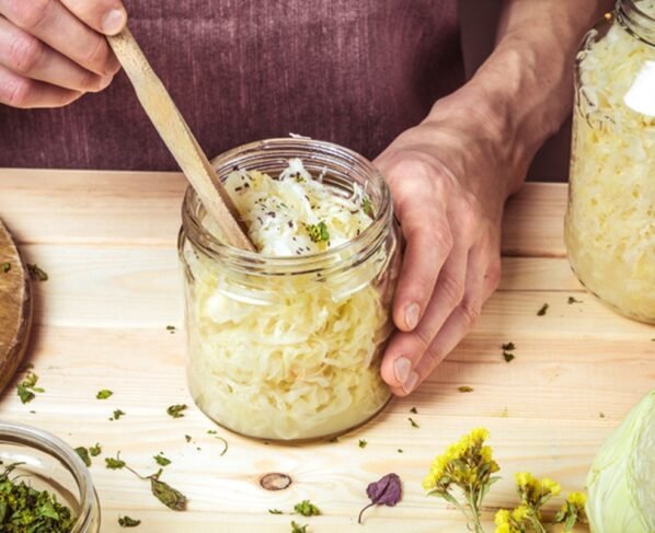 Mãos de homem seguram pote com chucrute - Metrópoles