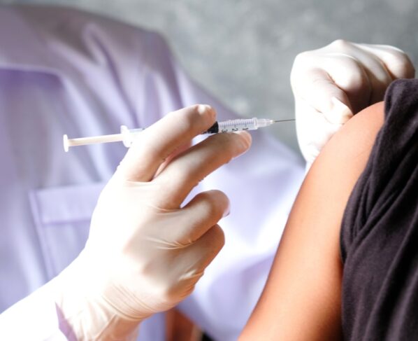 A mão do médico usa seringas para prevenir vírus. Injeção em criança ou mulher. Conceito de vacinação ou anticoncepcional injetável. Metrópoles
