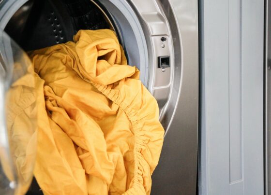 Imagem de roupas de cama em máquina de lavar - Metrópoles