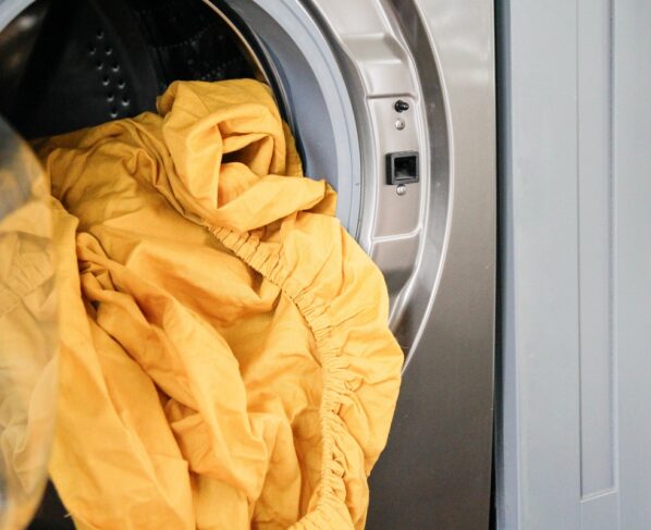 Imagem de roupas de cama em máquina de lavar - Metrópoles