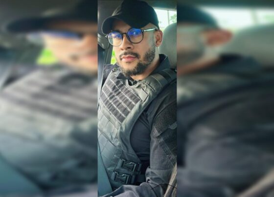 Homem de óculos com farda preta