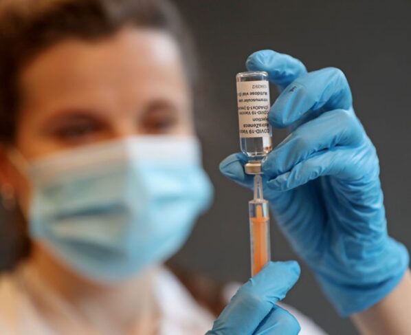 LONDRES, INGLATERRA - 12 DE MARÇO: A farmacêutica clínica Ellie Morton se prepara para administrar a vacina Oxford AstraZeneca COVID-19 no centro de vacinação comunitária do campus Penrhyn Road da Universidade de Kingston em 12 de março de 2021 em Londres, Inglaterra. Trabalhando em parceria com duas redes locais de cuidados primários, South West London CCG e Kingston Council, a Universidade transformou uma área do seu campus em Penrhyn Road num local de vacinação com 10 postos. (Foto de Chris Jackson/Getty Images)