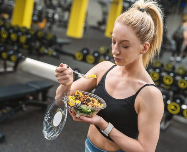 Foto de mulher comendo enquanto está na academia - Metrópoles
