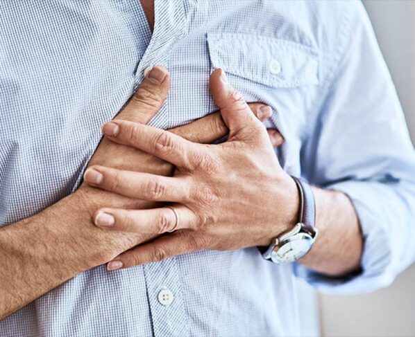Foto de um homem com camisa azul pressionando o peito - Metrópoles