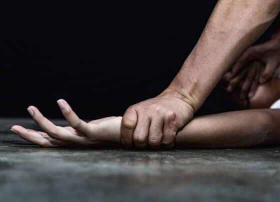Imagem colorida de homem segurando braço de mulher, simulando violência contra a mulher - Metrópoles