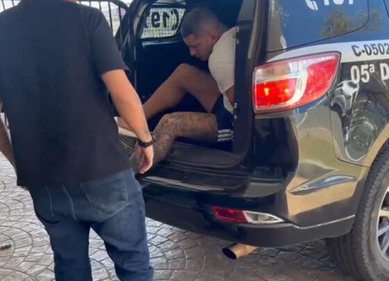 Homem preso descendo de camburão