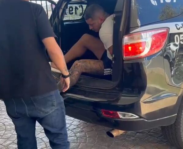 Homem preso descendo de camburão