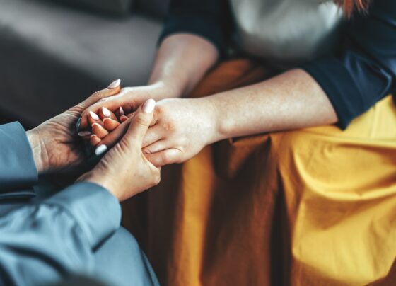 Foto colorida de duas pessoas dando as mãos - Boa morte