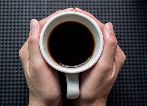 Foto colorida de mãos feminina segurando uma xícara de café, considerado alimento termogênico - Metrópoles
