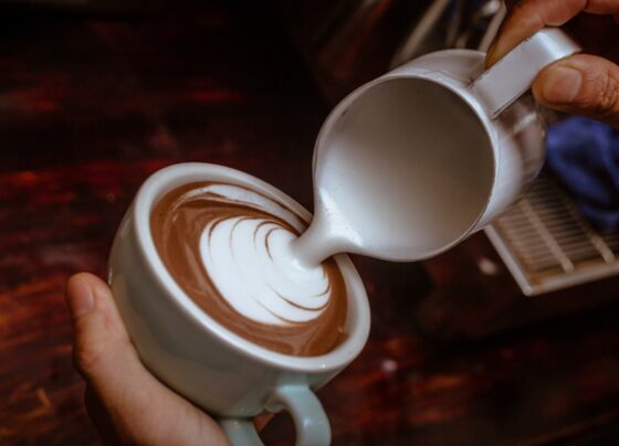 Foto colorida com mãos de homem fazendo um cappuccino - Metrópoles