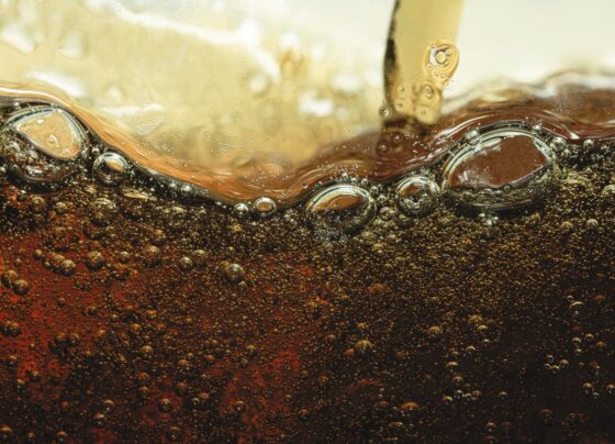 Imagem mostra refrigerante escuro com bolhas visto de perto - Metrópoles