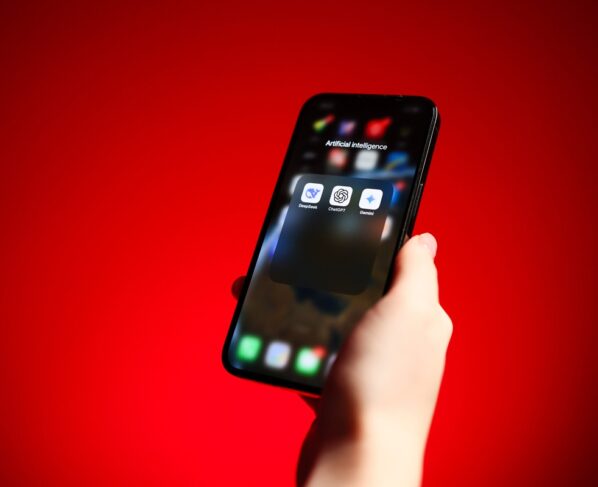 Mão segurando smartphone com aplicativos de assistente de IA de inteligência artificial - DeepSeek, Chat GPT, Google Gemini. Metrópoles