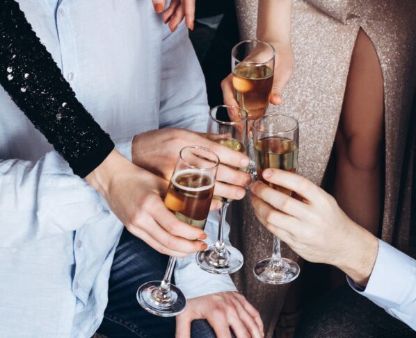 Imagem colorida mostra pessoas com taças na mão - Metrópoles