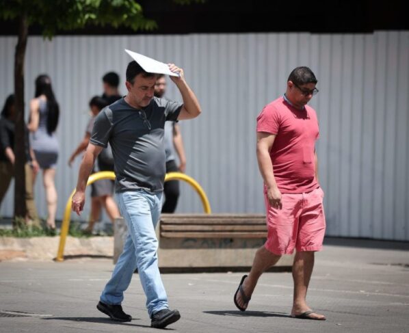 Imagem colorida mostra homem se protegendo do sol forte em São Paulo - Metrópoles