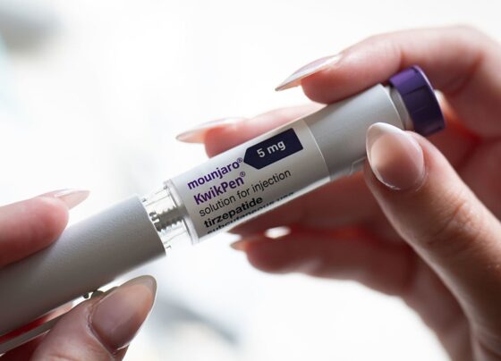 Uma mulher segura uma caneta injetora Mounjaro em 4 de outubro de 2025 em Cardiff, País de Gales. Metrópoles