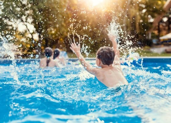 Foto colorida de crianças na piscina - Metrópoles