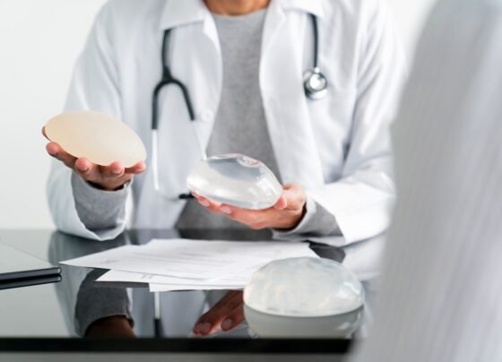 Imagem colorida de médica segurando próteses mamárias - Metrópoles