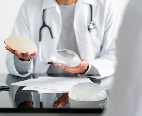 Imagem colorida de médica segurando próteses mamárias - Metrópoles