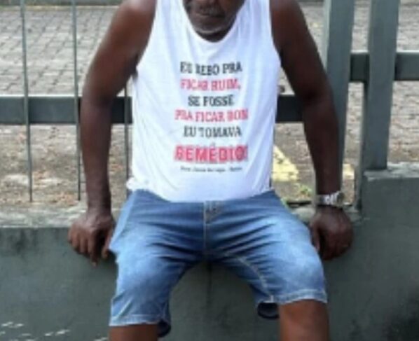 Imagem colorida de motorista usando camisa com estampa "bebo pra ficar ruim" - Metrópoles