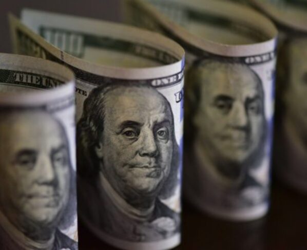 Imagem colorida de maços de notas de dólar norte-americano