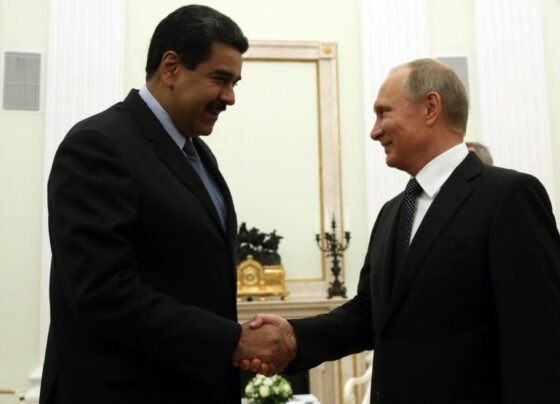 Imagem colorida mostra Putin e Maduro dando aperto de mão - Metrópoles