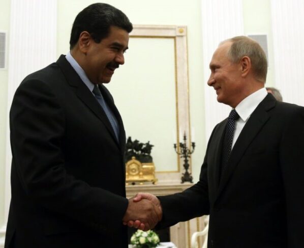 Imagem colorida mostra Putin e Maduro dando aperto de mão - Metrópoles