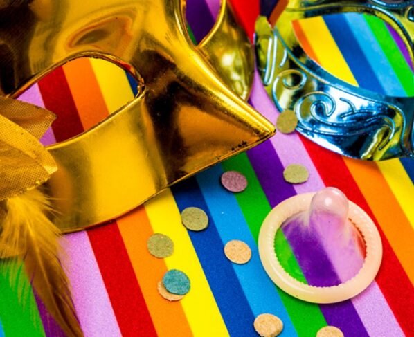 Foto com duas máscaras de Carnaval, camisinha e confete - Metrópoles - prevenção às ISTs