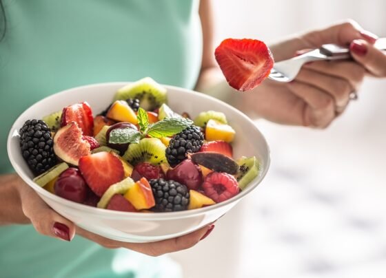 Mulher comendo tigela de frutas - metrópoles