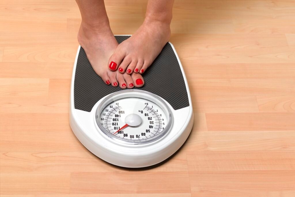 Foto colorida de pés de mulher em balança - Metrópoles