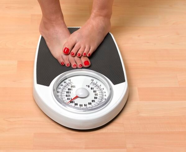 Foto colorida de pés de mulher em balança - Metrópoles