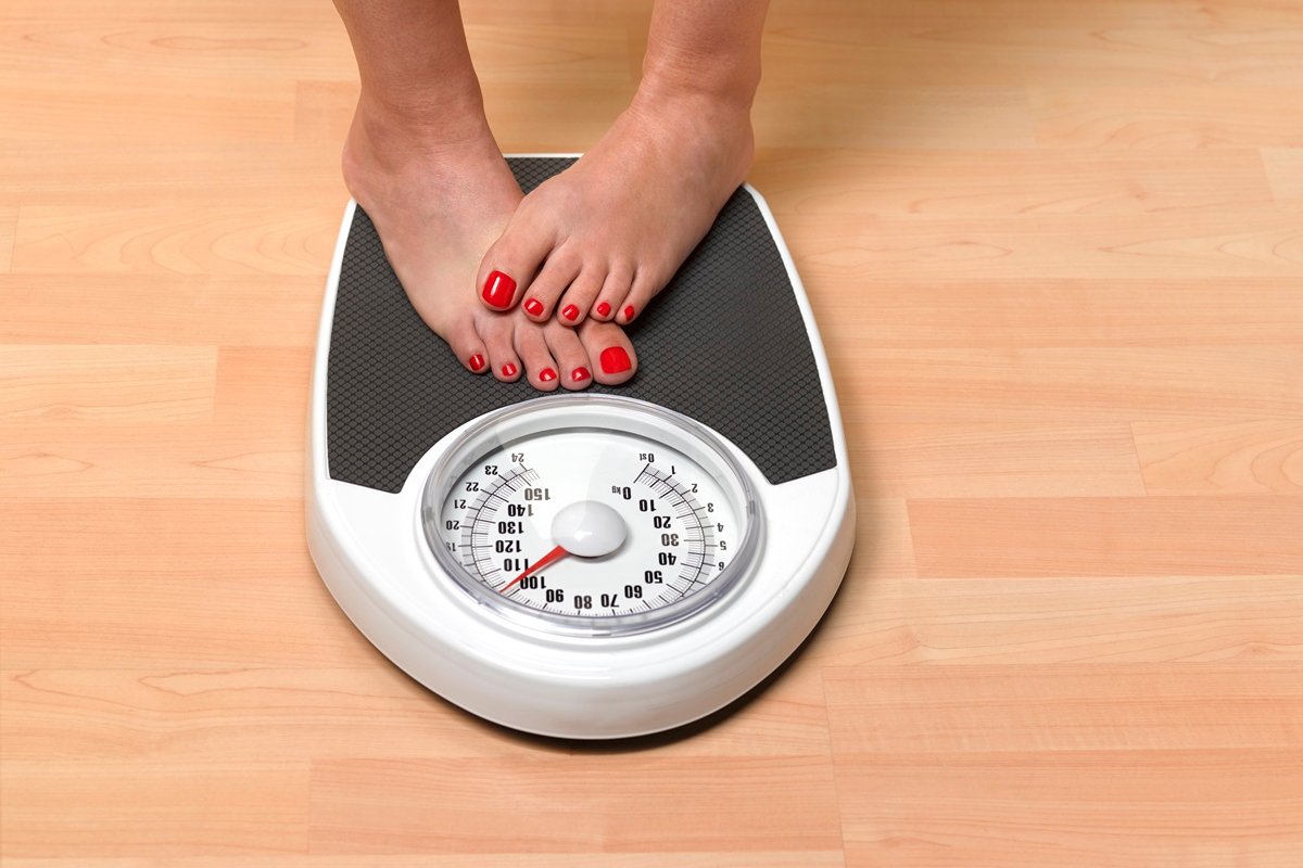 Foto colorida de pés de mulher em balança - Metrópoles