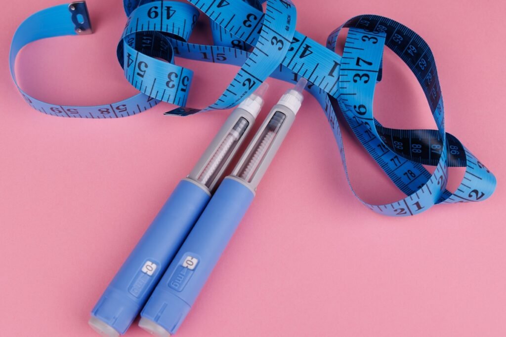 Foto colorida com fundo rosa de canetas emagrecedoras de cor azul - Metrópoles.