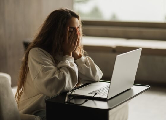 Foto colorida de pessoa triste no trabalho - Psicóloga explica por que lembramos da crítica e esquecemos o elogio - Metrópoles