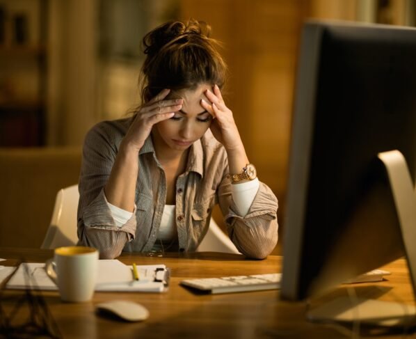 Foto colorida de mulher infeliz no trabalho - Psiquiatra explica o que é e como tratar depressão funcional - Metrópoles
