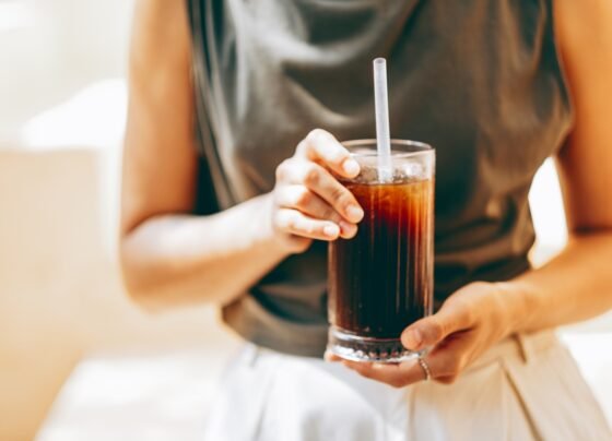 Foto de mulher segurando copo de refrigerante - Metrópoles