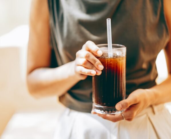 Foto de mulher segurando copo de refrigerante - Metrópoles