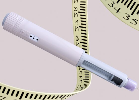 Renderização 3D de uma caneta injetora de agonista GLP-1, um medicamento para perda de peso, com uma fita métrica médica ou régua espiralando dinamicamente ao redor de sua forma. Metrópoles