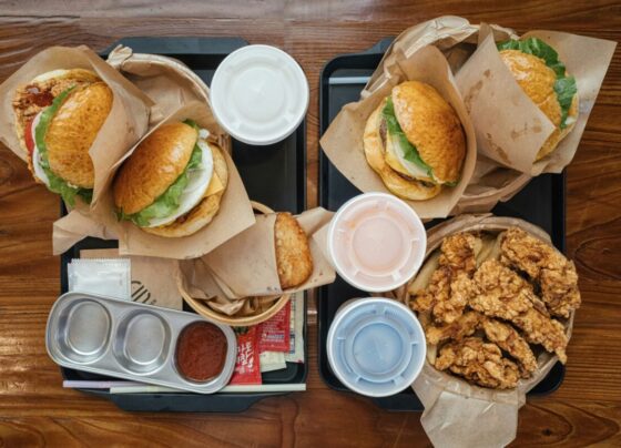 Fotografia colorida mostrando sanduíches e frituras em uma mesa-Metrópoles