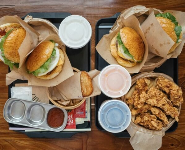 Fotografia colorida mostrando sanduíches e frituras em uma mesa-Metrópoles