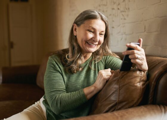 Senhora mexendo no celular- Metrópoles