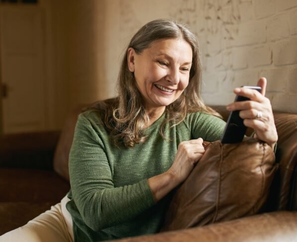 Senhora mexendo no celular- Metrópoles