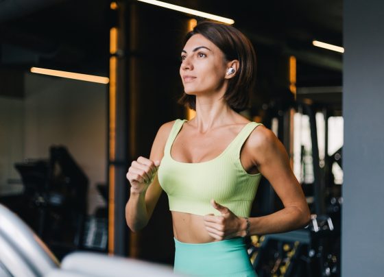 Mulher em treino na academia, correndo na esteira- Metrópoles