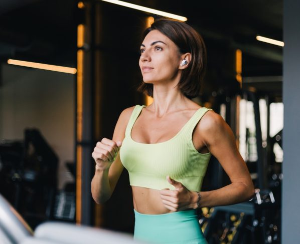 Mulher em treino na academia, correndo na esteira- Metrópoles